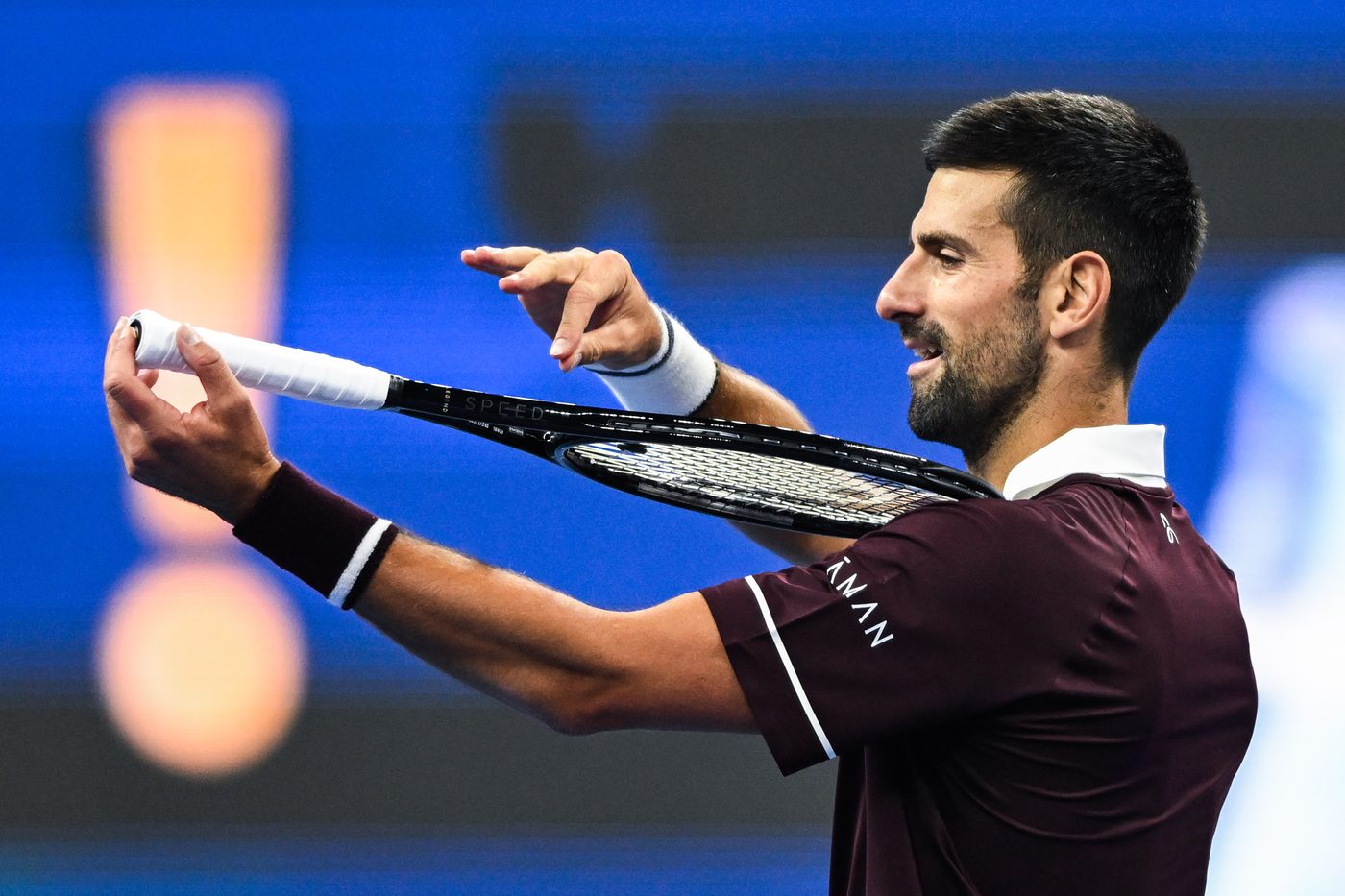 Novak Djokovic playing his racket like a violin while celebrating at the 2026 China Open.
